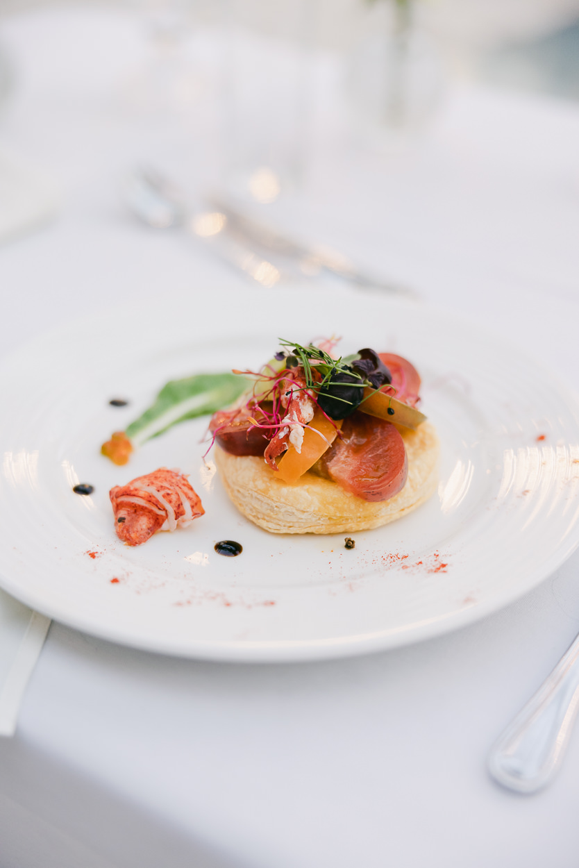 An exquisite dish from a wedding menu is presented on a white plate, showcasing the fine dining experience characteristic of Provence culinary style.